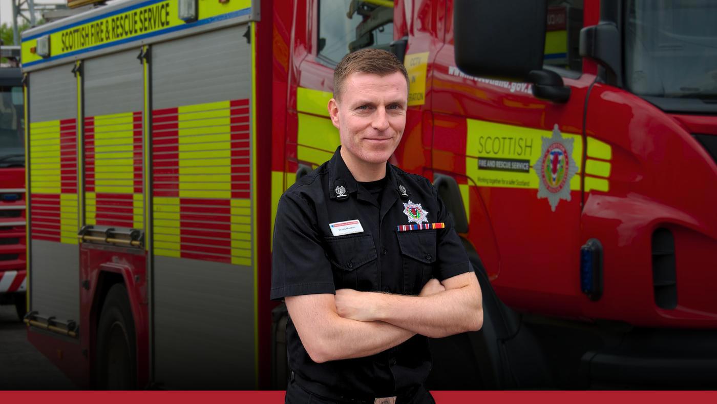 Firefighter standing in front of a fire appliance