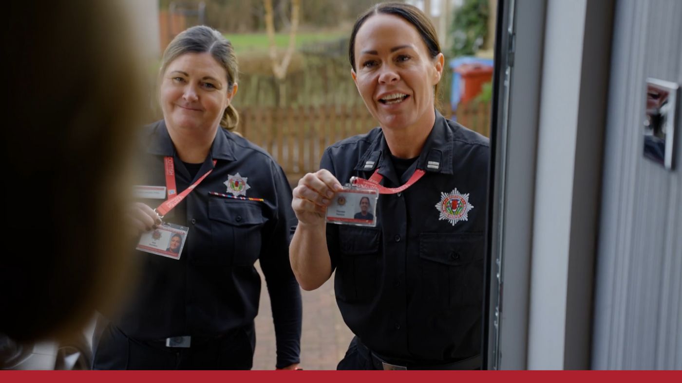 Two women in uniform proudly display their badges, symbolising their roles and commitment to serving the community.