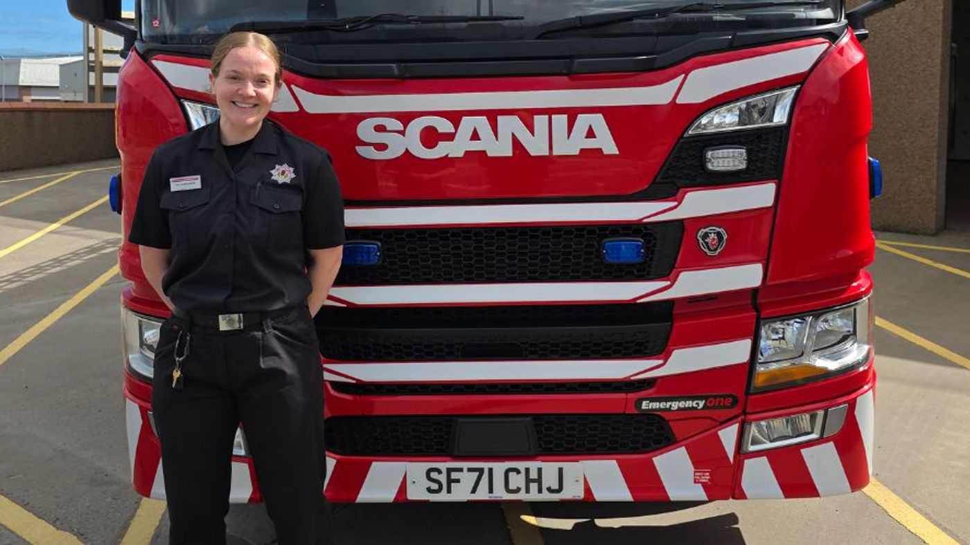 Firefighter standing in front of a fire engine