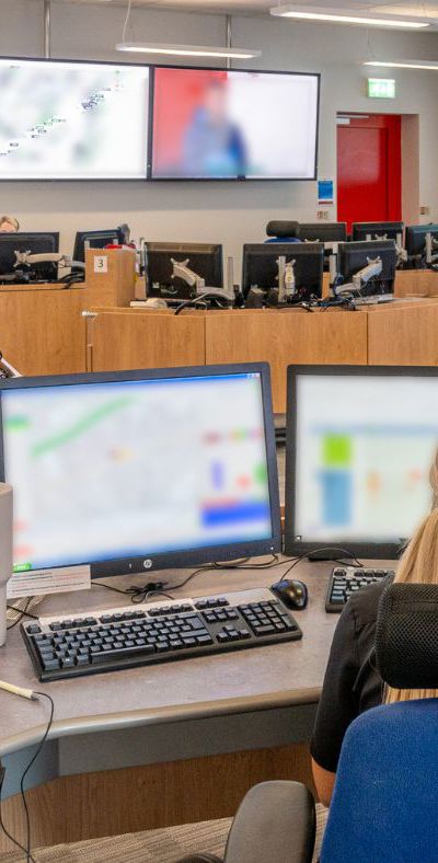 A large Operations Control room where multiple firefighters control are engaged in computer work.