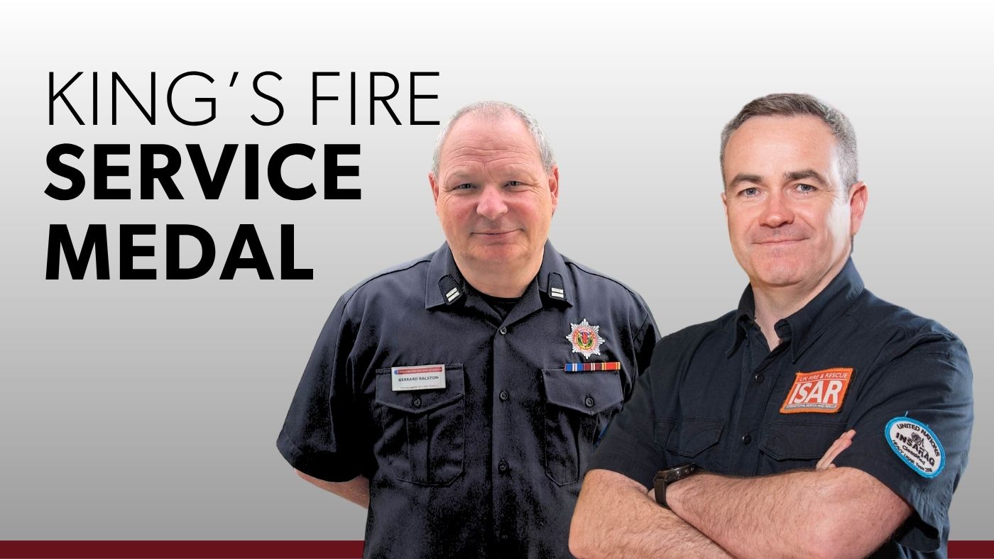 Two uniformed men stand together, showcasing the King's Fire Service Medal.