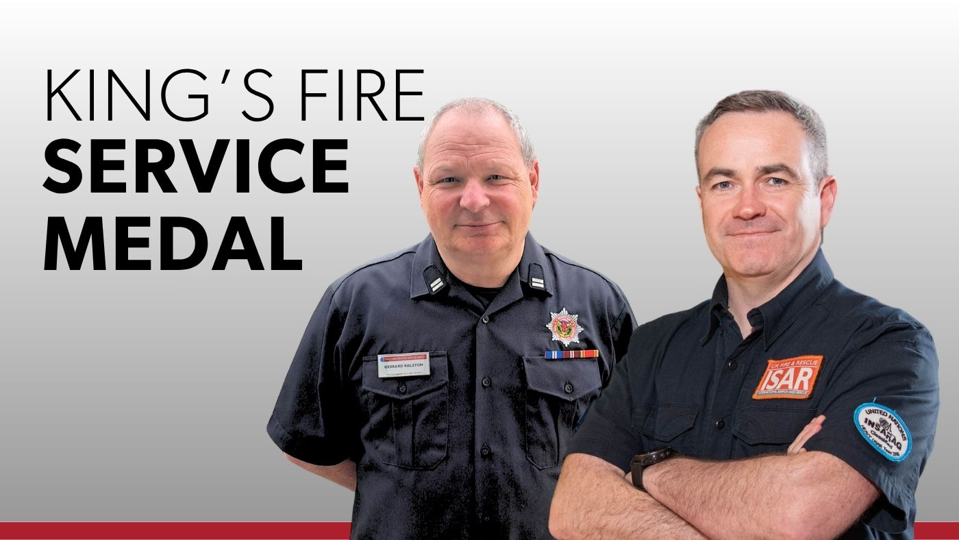 Two uniformed men stand together, showcasing the King's Fire Service Medal.