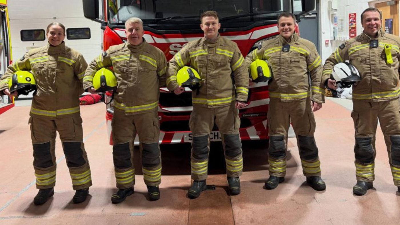 Firefighters standing in front of a fire engine