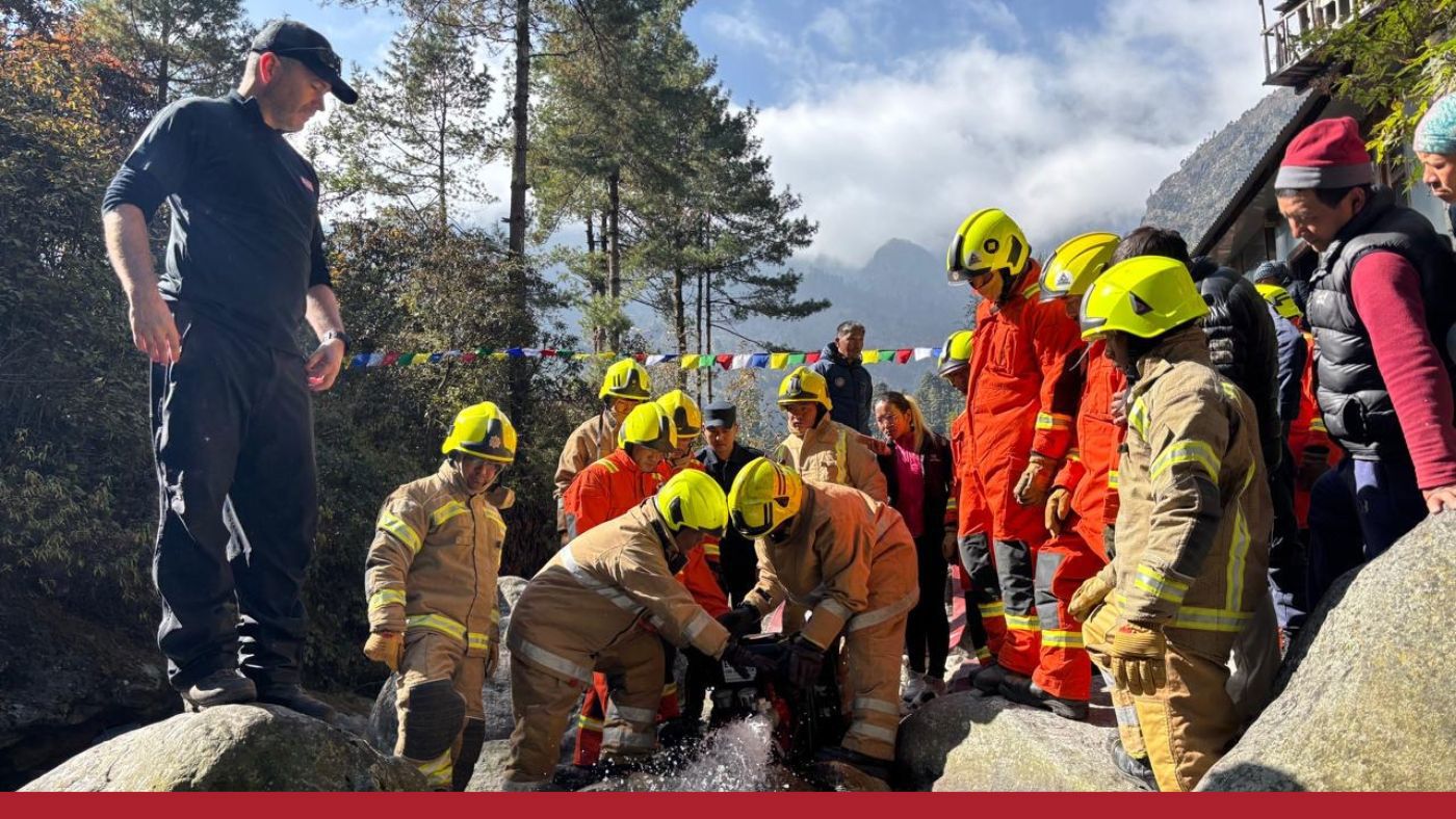 A group of individuals in firefighting uniforms is standing on rocks, participating in rescue training.