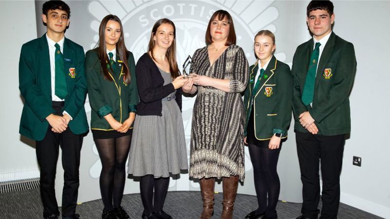 Group of young people in green school uniform acceptingan award