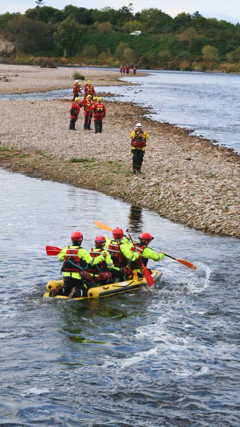 a group of people in a river for a water rescue exercise