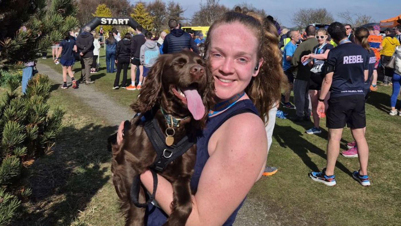 Girl at a running event holding a dog