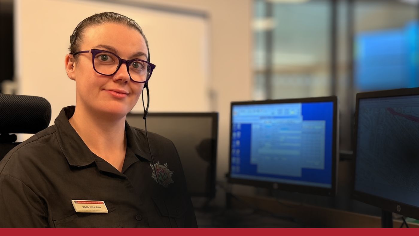 A woman in a black uniform sits at a desk, focused on her work in a professional setting.
