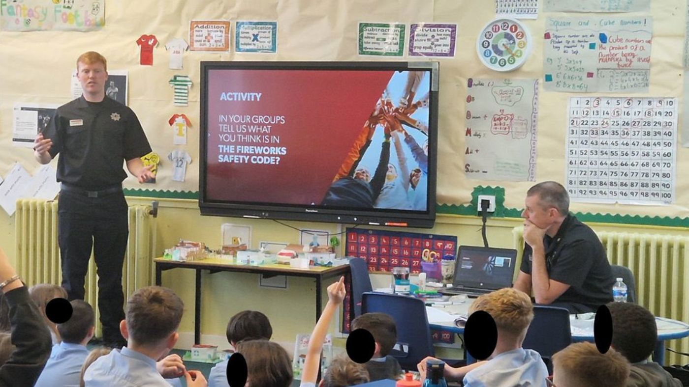 Firefighters giving a presentation to children in a classroom