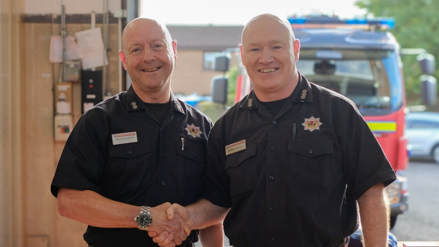Picture of Colin Hutcheson who is standing on the left shaking hands with Station Commander Russell Hammell