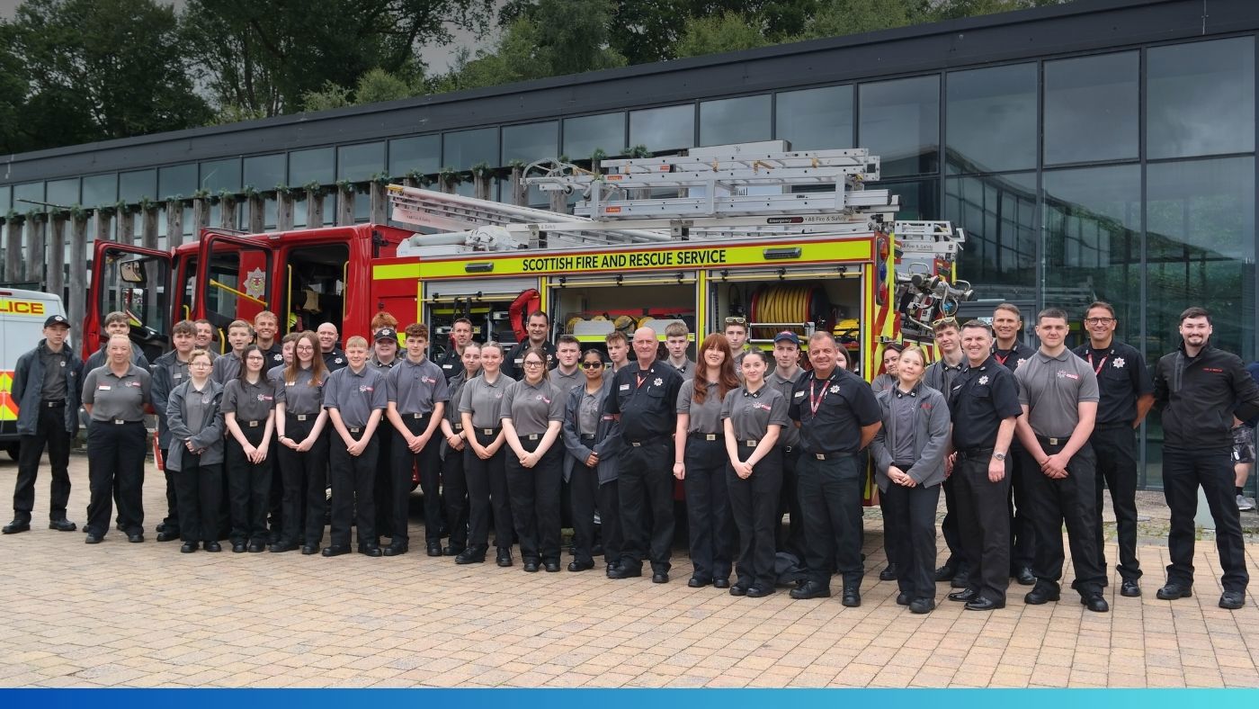 A gathering of people poses in front of a fire engine.