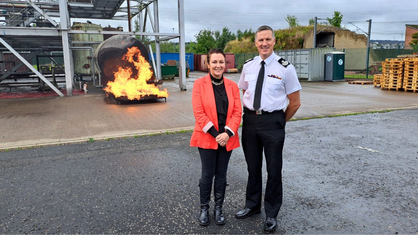 2 people standing in front of a fire