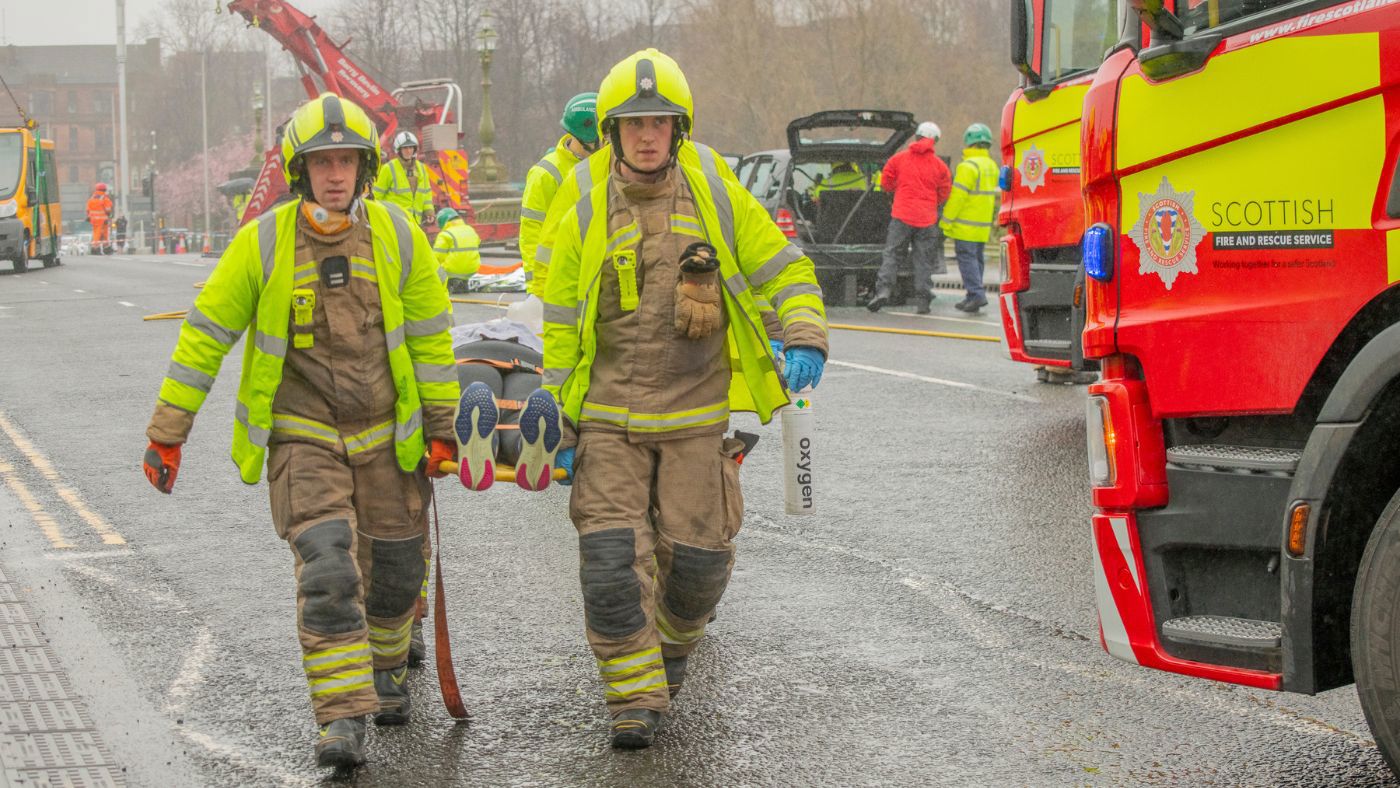 Firefighters carrying casualty in a stretcher.