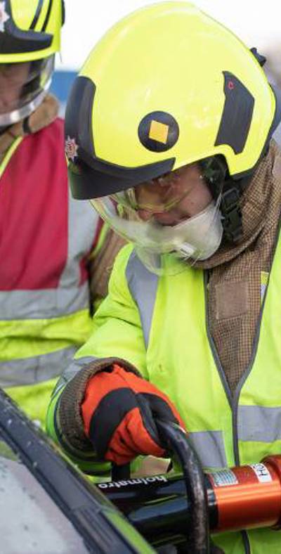 Firefighters cutting into a car using cutting equipment